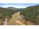 Picturesque aerial view of a valley surrounded by mountains and lush green forests at 7510 Blue Creek Rd, Evergreen, CO 80439