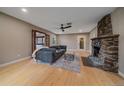 Inviting living room featuring a stone fireplace, a cozy couch, and wood flooring at 7510 Blue Creek Rd, Evergreen, CO 80439