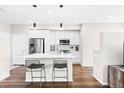 Sleek, modern kitchen with white cabinets, stainless steel appliances, and island with breakfast bar at 6764 Osage St, Denver, CO 80221