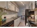 Well-lit kitchen featuring white cabinets, granite countertops and stainless appliances at 7755 E Quincy Ave # 104A1, Denver, CO 80237