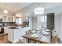 Bright kitchen flows seamlessly into the dining area and features white cabinets and sleek countertops at 6365 Xavier Ct, Arvada, CO 80003