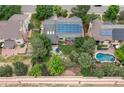Aerial view of a home with solar panels, patio dining, firepit, and a pool in the neighboring yard at 8291 S Krameria Way, Centennial, CO 80112