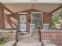Cozy front porch featuring brick pillars and classic rocking chairs, perfect for relaxing outdoors at 2303-2305 W 32Nd Ave, Denver, CO 80211
