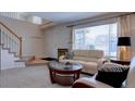 Bright living room featuring neutral décor, large window and staircase at 10272 Fawnbrook Ct, Highlands Ranch, CO 80130