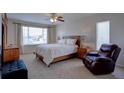 Spacious main bedroom featuring a king-size bed and a cozy armchair at 10272 Fawnbrook Ct, Highlands Ranch, CO 80130