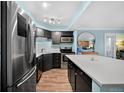The kitchen has modern stainless steel appliances, dark cabinetry, and a center island at 1301 Speer Blvd # 207, Denver, CO 80204