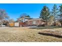 Exterior view of a home with lawn, mature trees, and an attached garage at 5404 W Rowland Pl, Littleton, CO 80128