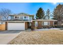 Charming two-story home with a brick facade, well-maintained landscaping, and an attached two-car garage at 5404 W Rowland Pl, Littleton, CO 80128