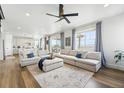 Spacious living room featuring hardwood floors, large windows, and comfortable sectional sofas at 1601 Mariah Ln, Erie, CO 80516