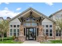 Daytime view of the building entrance featuring stone pillars, many windows, and peaked roof design at 7212 S Blackhawk St # 1-103, Englewood, CO 80112