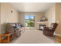 Cozy living room features a stone fireplace, plush seating, and a sliding door to the outside at 7212 S Blackhawk St # 1-103, Englewood, CO 80112