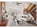 Bright living room features a brick fireplace, a bay window, and staircase at 1206 E Phillips Pl, Littleton, CO 80122