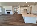 Open-concept kitchen and living room boasting wood floors, ample natural light, and modern finishes at 4609 Thistle Dr, Brighton, CO 80601