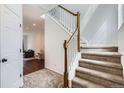Bright foyer with a staircase featuring wood railing and neutral carpet at 2139 Coronado Pkwy # B, Denver, CO 80229