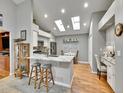 Bright kitchen with granite counters, island seating, skylights, and hardwood floors at 5231 S Cody St, Littleton, CO 80123