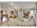 Cozy living room with a brick fireplace, wood floors, and lots of natural light at 5231 S Cody St, Littleton, CO 80123