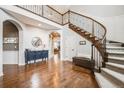 Grand entryway with wood floors, staircase, and views into other rooms at 10738 Braesheather Ct, Highlands Ranch, CO 80126