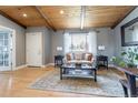 Bright living room with wood ceiling, hardwood floors, and a large window overlooking the street at 13020 Julian Ct, Broomfield, CO 80020