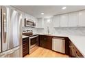 Modern kitchen featuring stainless steel appliances, quartz countertops, and wood floors at 8418 Everett Way # C, Arvada, CO 80005