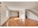 Inviting living room with fireplace, gleaming hardwood floors, large windows and staircase at 8418 Everett Way # C, Arvada, CO 80005