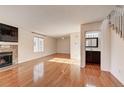 Bright living room featuring hardwood floors, fireplace, and half bathroom with stylish vanity and modern fixtures at 8418 Everett Way # C, Arvada, CO 80005