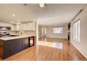 Open-concept living space features updated kitchen, wood floors, and abundant natural light at 8418 Everett Way # C, Arvada, CO 80005