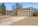Brick home with a large two-car garage and extended driveway at 16755 E Union Ave, Aurora, CO 80015