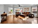 An open-concept living room shows the hardwood floors, leather furniture, and connections to other spaces at 5577 Jasper St, Denver, CO 80239
