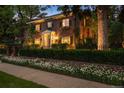 Beautiful brick home with manicured landscaping, flower boxes, and warm lighting at 6300 E 17Th Avenue Pkwy, Denver, CO 80220