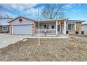 Classic home with gray siding, brick accents, and a welcoming front porch and green space at 3863 S Bahama St, Aurora, CO 80013