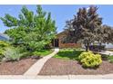 Beautiful brick home with mature trees, lush landscaping, and a welcoming walkway at 4720 S Grant St, Englewood, CO 80113