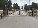 View of gated entrance to a private drive with stone pillars and a decorative metal gate at 4948 Cameyo Rd, Indian Hills, CO 80454