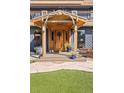 Inviting front entrance with a wooden door, charming decor and tasteful landscaping at 4948 Cameyo Rd, Indian Hills, CO 80454
