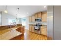 Bright kitchen features stainless steel appliances, granite countertops, and hardwood floors, combining style and functionality at 8199 W 67Th Ave, Arvada, CO 80004