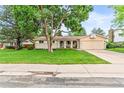 Inviting single-story home with a well-maintained lawn, mature tree, and attached garage at 7442 S Wellington St, Centennial, CO 80122