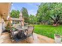 Outdoor patio with dining set and string lights, perfect for enjoying the lush backyard at 7442 S Wellington St, Centennial, CO 80122
