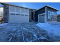 Modern home exterior with gray siding, stone accents, and a two-car garage at 24720 E 36Th Ave, Aurora, CO 80019