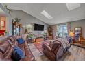 Bright living room showcasing a vaulted ceiling, skylight, comfortable seating, and views of the outdoors at 6085 S Parfet St, Littleton, CO 80127