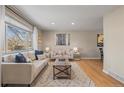 Bright and airy living room featuring hardwood floors, stylish decor, and a large window offering picturesque views at 9598 Lou Dr, Northglenn, CO 80260