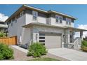 Modern home featuring stone accents, a two-car garage with a contemporary door, and low-maintenance landscaping at 6558 Kenzie Cir, Castle Pines, CO 80108
