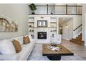 Elegant living room featuring a cozy fireplace, built-in shelving, and an open layout for comfortable living at 6558 Kenzie Cir, Castle Pines, CO 80108