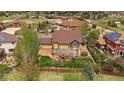 Aerial view of a home's expansive backyard with a wooden fence, lawn, and mature trees at 15258 W 75Th Pl, Arvada, CO 80007