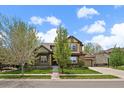 Charming home showcasing a beautifully landscaped front yard, inviting porch, and attached garage at 15258 W 75Th Pl, Arvada, CO 80007