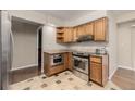 Bright kitchen featuring stainless steel appliances, granite counters, and stylish tile flooring at 7250 Eastmoor Dr # 105, Denver, CO 80237