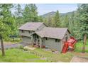 Two-story home with attached garage, front porch, landscaping, and outdoor deck at 28065 Camel Heights Cir, Evergreen, CO 80439