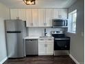 Close-up of kitchen with white cabinets, stainless steel appliances, and tile backsplash at 1285 Colorado Blvd # 3, Denver, CO 80206
