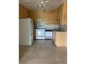 The kitchen has neutral cabinets, white appliances, and neutral floors at 9335 E Center Ave # 7C, Denver, CO 80247