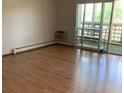 Bright living room with hardwood floors, a sliding glass door, and an air conditioner at 9335 E Center Ave # 7C, Denver, CO 80247