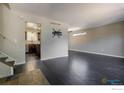 Spacious living room featuring dark wood floors, modern fixtures and access to the kitchen at 10560 W 102Nd Pl, Broomfield, CO 80021