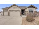 Charming ranch-style home with stone accents, a three-car garage, and a landscaped front yard at 10882 E 162Nd Pl, Brighton, CO 80602